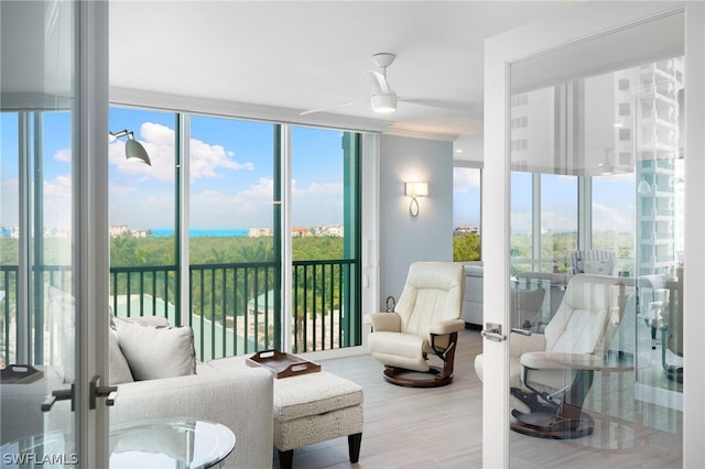 sunroom / solarium featuring french doors and ceiling fan