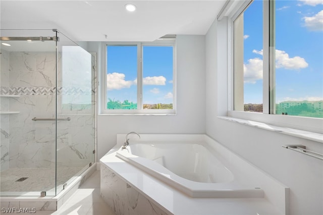 bathroom with shower with separate bathtub and a healthy amount of sunlight