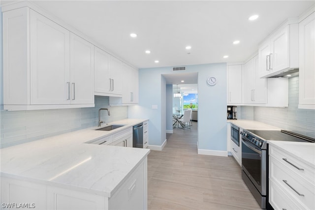 kitchen with appliances with stainless steel finishes, sink, and white cabinets