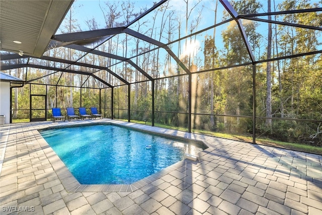 view of swimming pool featuring a lanai and a patio area