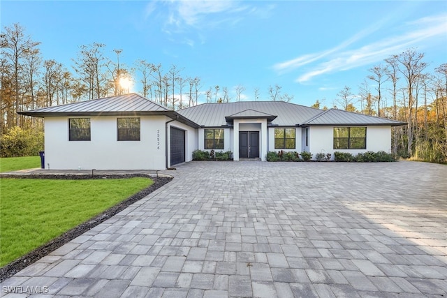 view of front of house with a garage and a front lawn