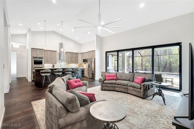 living room with dark wood-type flooring, high vaulted ceiling, and a chandelier