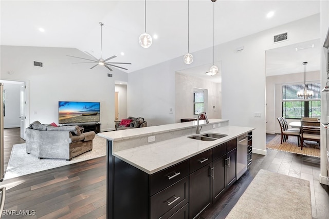 kitchen featuring lofted ceiling, dark hardwood / wood-style flooring, an island with sink, and hanging light fixtures