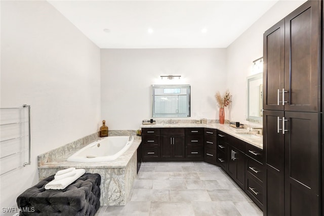 bathroom featuring a relaxing tiled tub and vanity