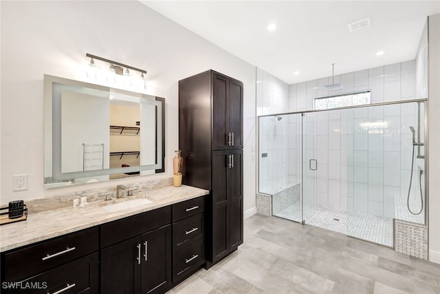 bathroom with vanity and a shower with door