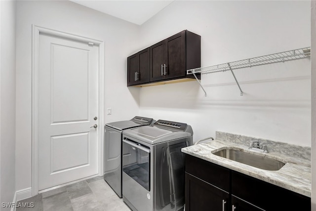 laundry area with cabinets, washing machine and dryer, and sink