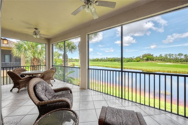 sunroom / solarium with a water view and ceiling fan