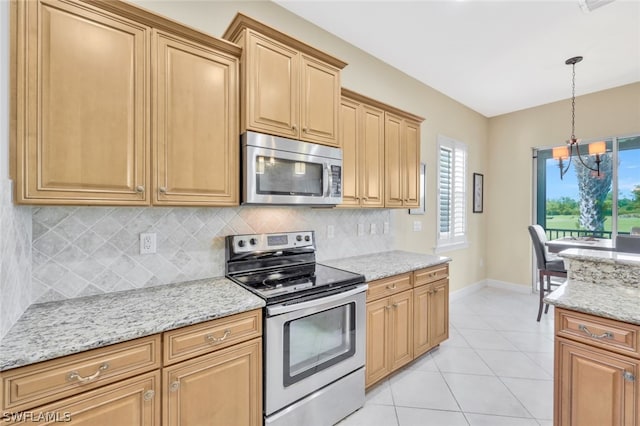 kitchen with light stone countertops, appliances with stainless steel finishes, decorative light fixtures, decorative backsplash, and light tile patterned floors