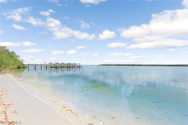 dock area with a water view and a beach view