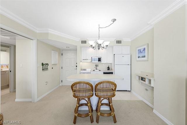 kitchen with light countertops, stainless steel microwave, visible vents, freestanding refrigerator, and white cabinetry