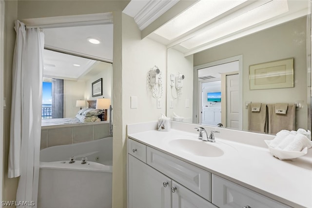 bathroom with vanity, ensuite bath, and a tub with jets