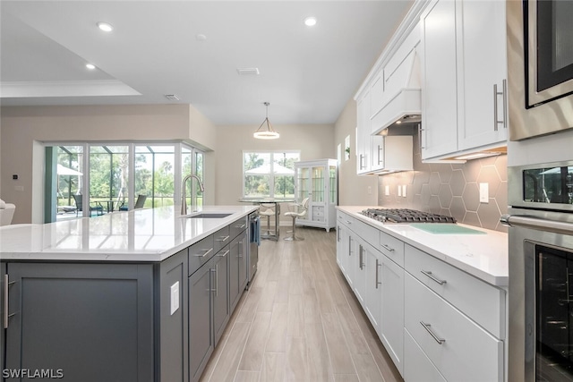 kitchen with white cabinets, sink, and an island with sink