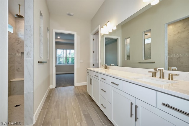 bathroom featuring tiled shower and vanity