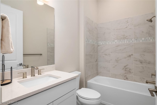 full bathroom featuring vanity, tiled shower / bath combo, and toilet