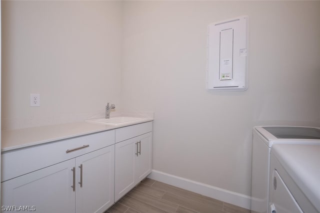 laundry area with cabinets, separate washer and dryer, and sink