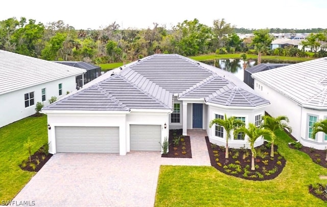 view of front of property featuring a front lawn, a water view, and a garage