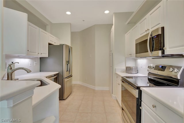 kitchen featuring white cabinets, stainless steel appliances, light tile patterned flooring, and sink