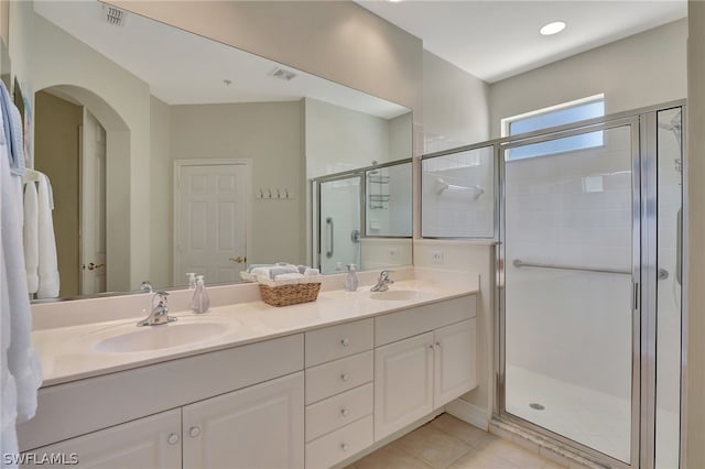 bathroom with tile patterned floors, vanity, and a shower with door