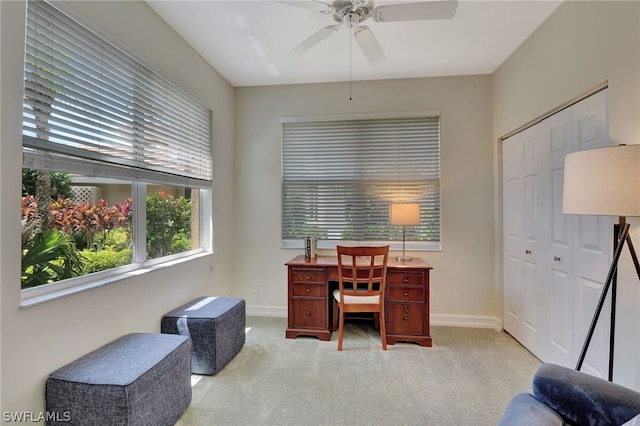 carpeted home office featuring ceiling fan