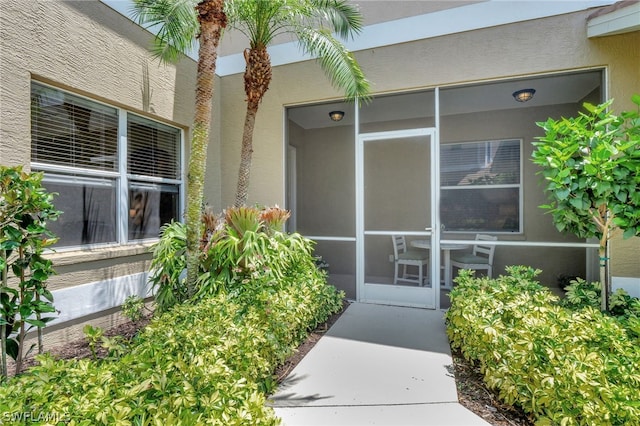 entrance to property featuring stucco siding