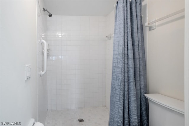 bathroom featuring toilet and curtained shower