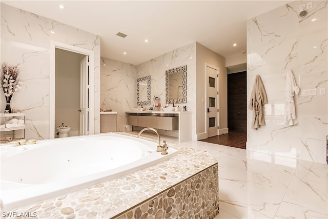 bathroom with tiled bath, tile walls, hardwood / wood-style flooring, and vanity