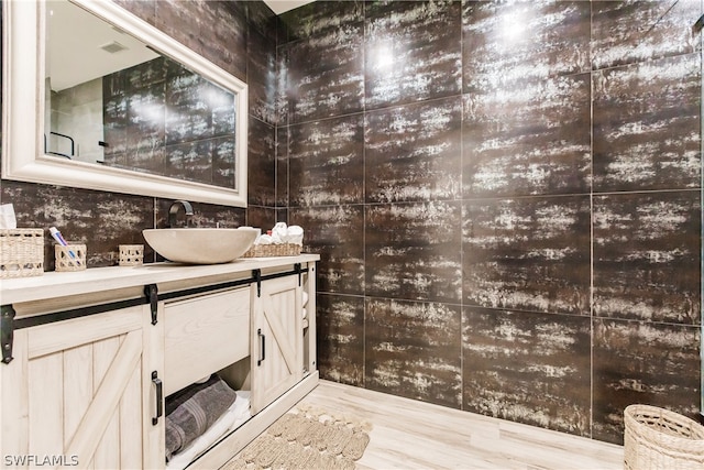 bathroom with vanity, tile walls, and hardwood / wood-style flooring