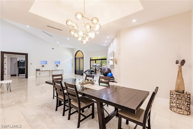 tiled dining room with high vaulted ceiling and an inviting chandelier