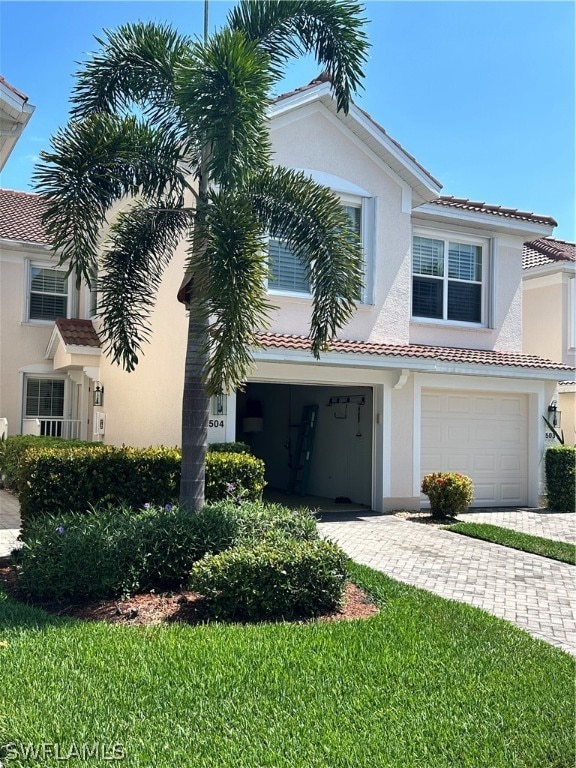 view of front of home with a garage and a front lawn