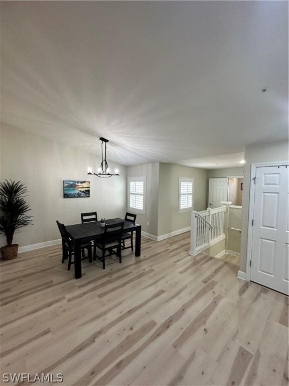 dining space with a notable chandelier and light hardwood / wood-style flooring