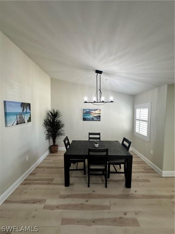 dining space featuring light hardwood / wood-style floors and a chandelier