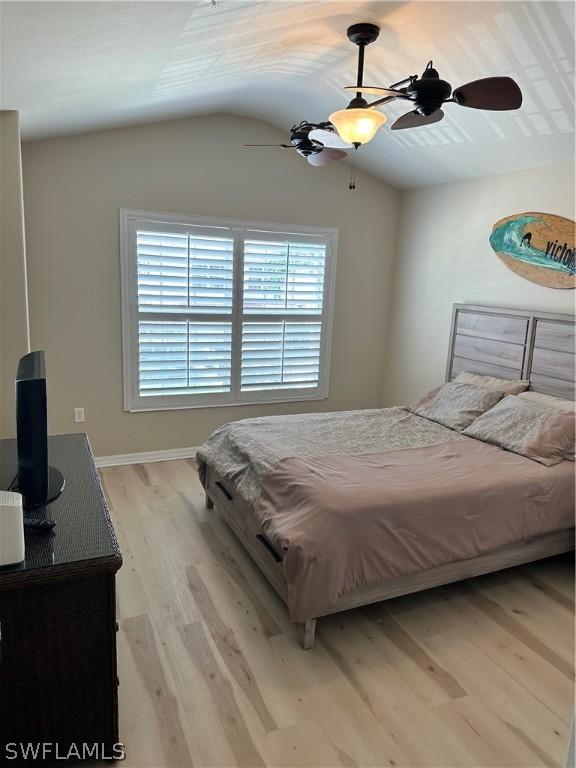 bedroom featuring ceiling fan, vaulted ceiling, and light wood-type flooring