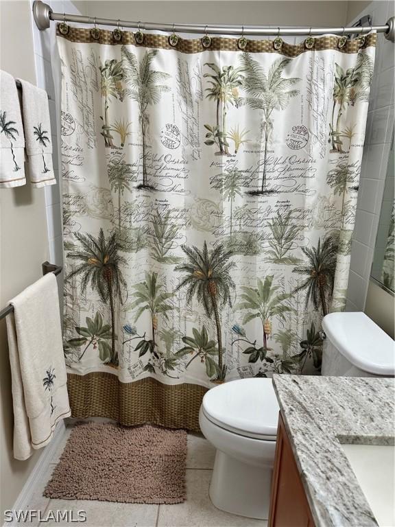 bathroom with a shower with shower curtain, vanity, toilet, and tile patterned flooring