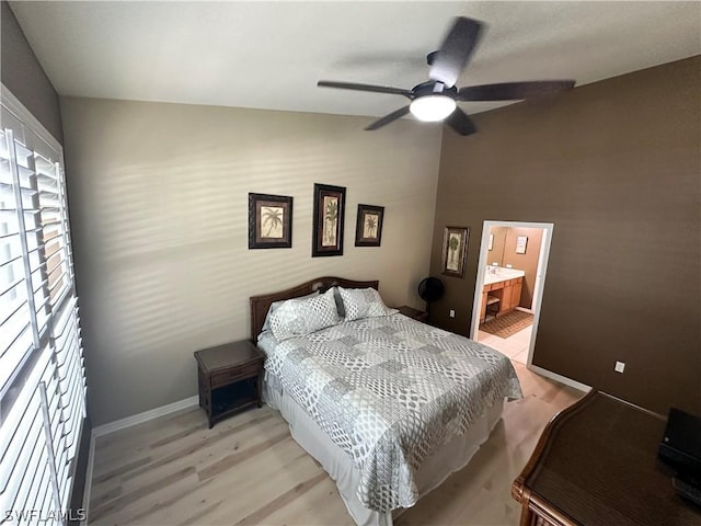 bedroom with ensuite bath, light hardwood / wood-style flooring, and ceiling fan