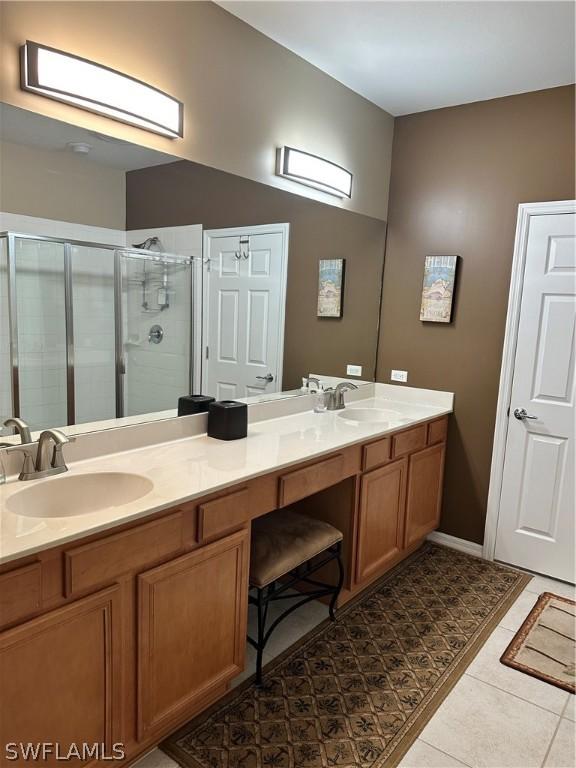 bathroom with vanity, an enclosed shower, and tile patterned floors