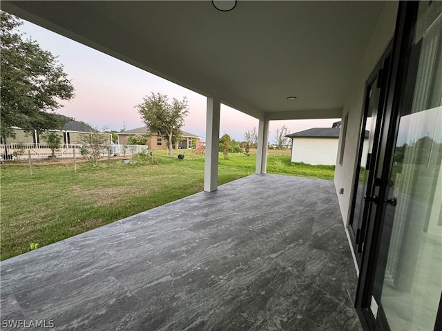 deck at dusk with a patio area and a yard