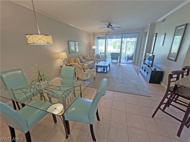 tiled dining space featuring ceiling fan and crown molding