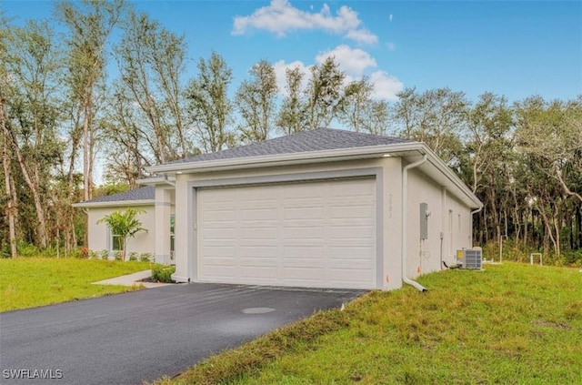 garage with a lawn and central air condition unit