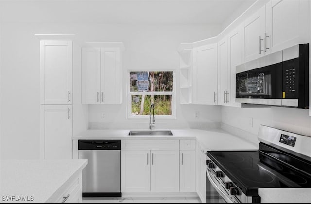 kitchen with white cabinetry, stainless steel appliances, and sink