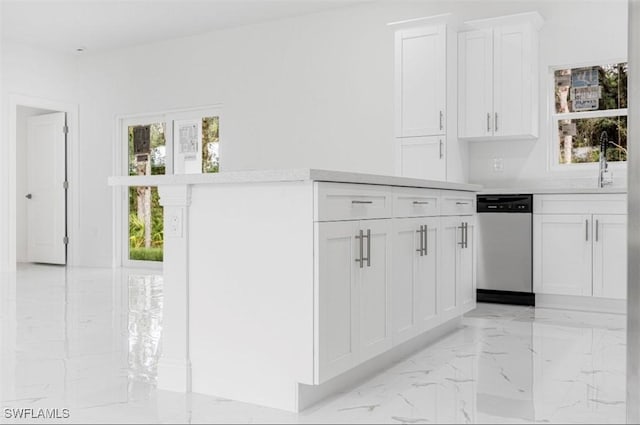 kitchen featuring white cabinetry, stainless steel dishwasher, and sink