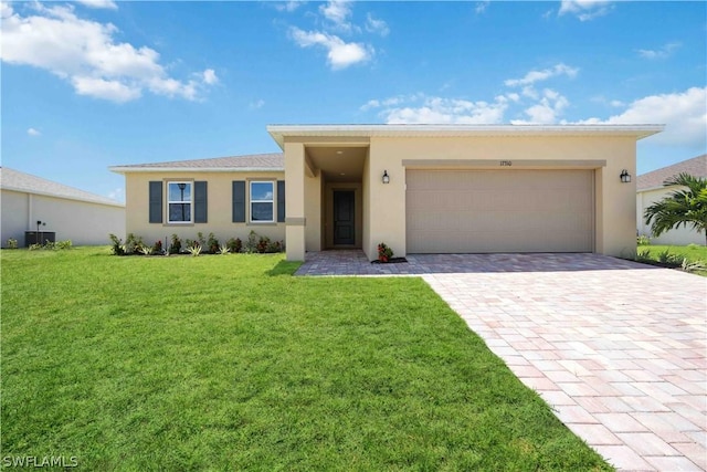 view of front of home featuring a front yard, a garage, and central AC unit