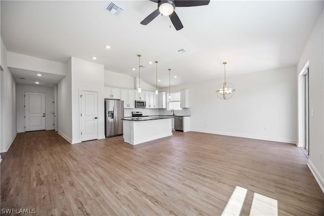 kitchen featuring hanging light fixtures, white cabinets, ceiling fan with notable chandelier, a center island, and stainless steel appliances