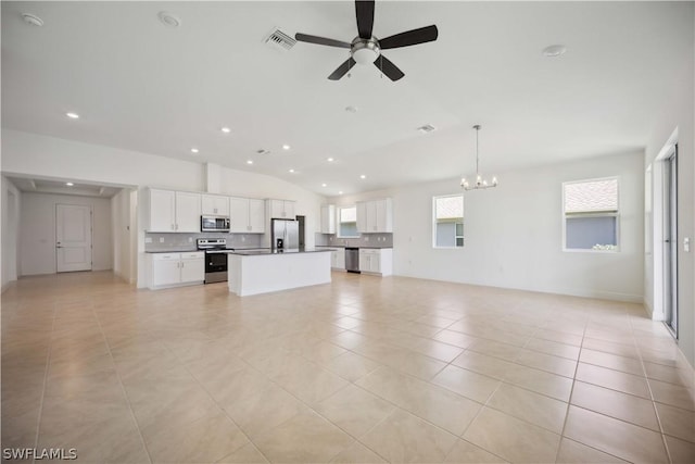 unfurnished living room with light tile patterned floors, lofted ceiling, and ceiling fan with notable chandelier