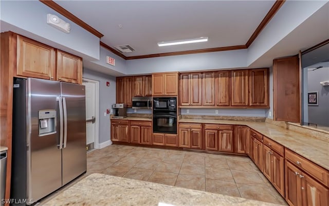 kitchen with black appliances, brown cabinetry, crown molding, and visible vents