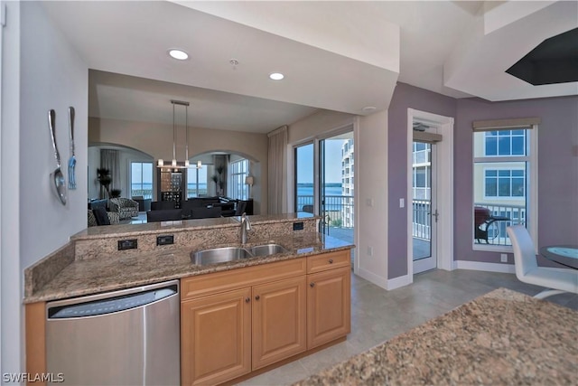 kitchen with light stone counters, recessed lighting, a sink, dishwasher, and a chandelier