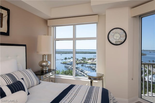 bedroom with baseboards and a water view