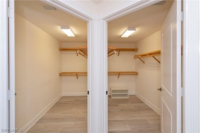 walk in closet with light wood-type flooring and visible vents