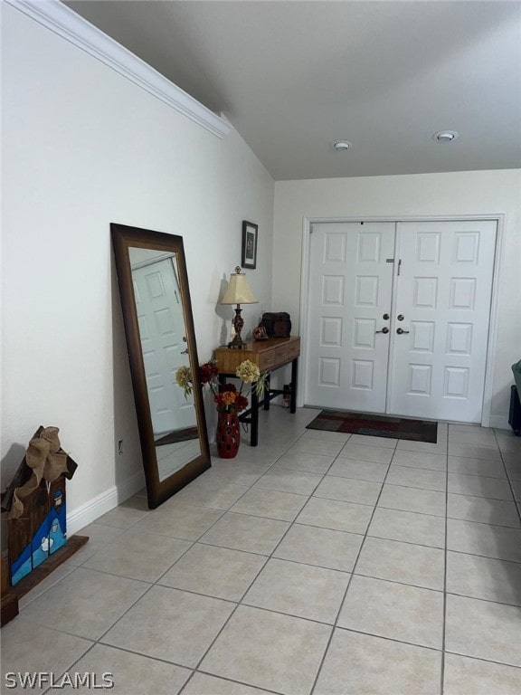 tiled entryway with french doors and crown molding