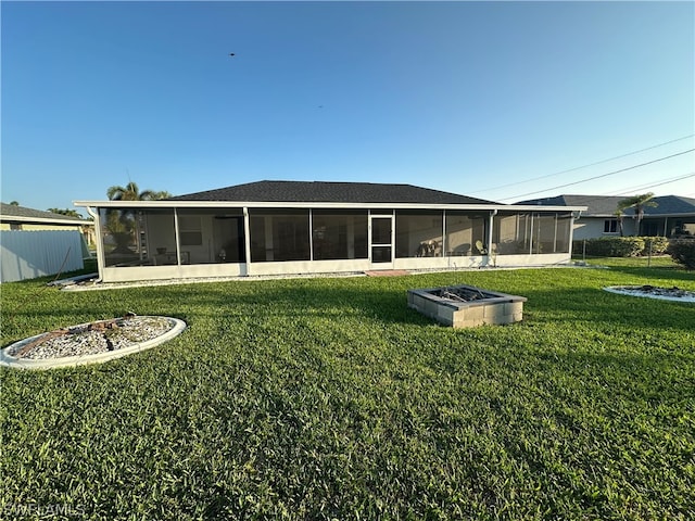 back of house featuring a yard and a sunroom