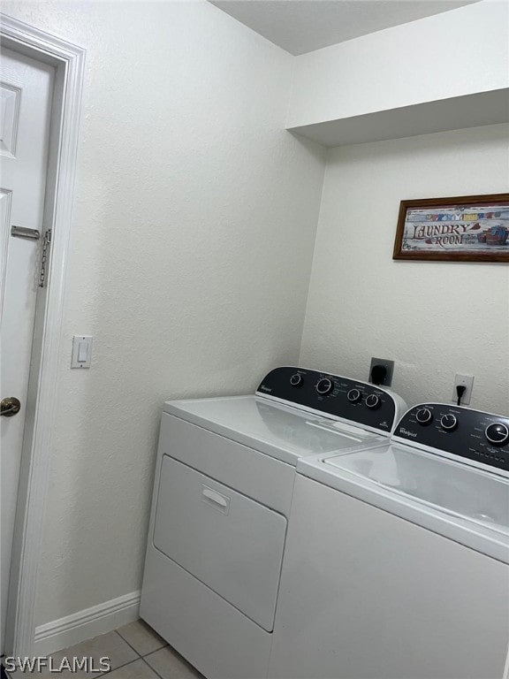 clothes washing area with electric dryer hookup, independent washer and dryer, and light tile floors